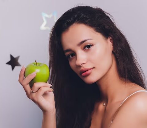 Mulher segurando uma maçã verde