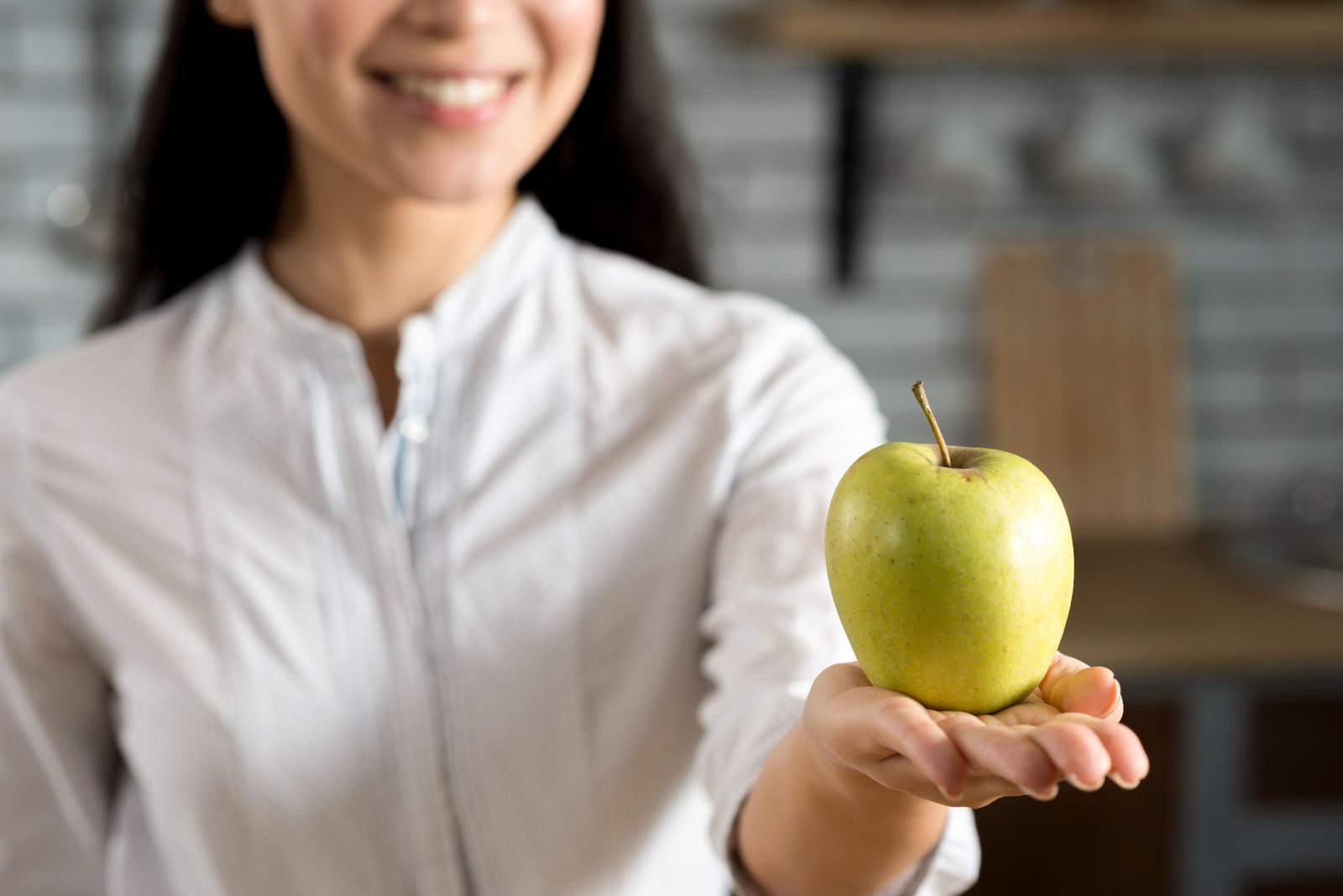 Nutricionista segurando uma maçã verde